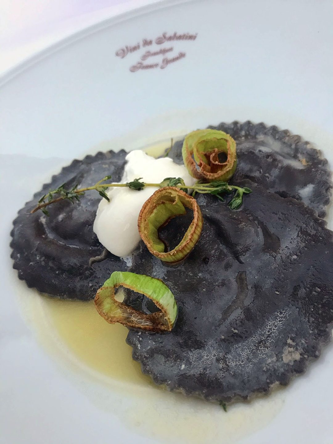 Schwarze Ravioli mit Lauchringen und Thymian